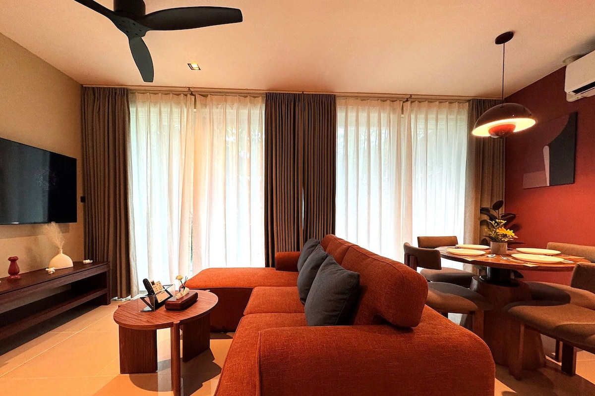 A modern living room with a sofa, coffee table, and dining area.