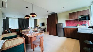 Una sala moderna con comedor, cocina y televisor de pantalla plana.