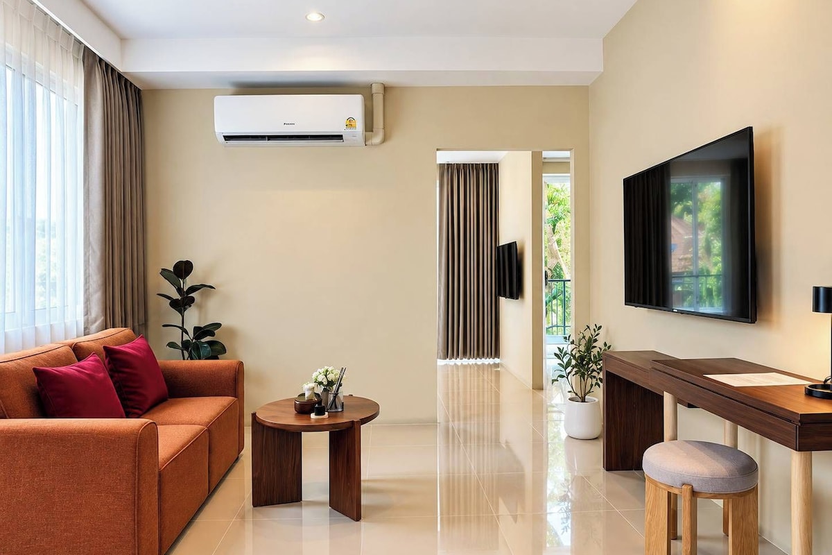 Una sala de estar moderna con un sofá, una mesa de centro, un televisor y un escritorio con una silla.