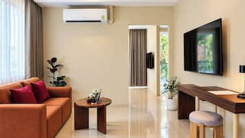 Una sala de estar moderna con un sofá, una mesa de centro, un televisor y un escritorio con una silla.