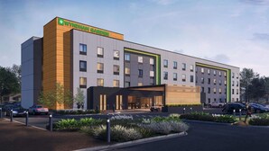Un hôtel moderne, reconnaissable à son grand panneau « WYNDHAM GARDEN », qui s’étend sur plusieurs étages et possède une entrée abritée.