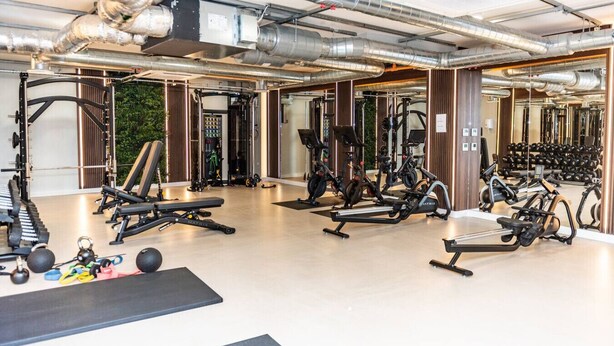 A gym with various exercise equipment, including treadmills, stationary bikes, and free weights. - Belgrave Village Home: Patio, Parking & Gym (Balsall Heath)