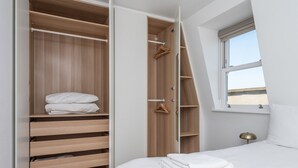 Une chambre avec un grand placard, un lit et une fenêtre donnant sur un beau paysage.