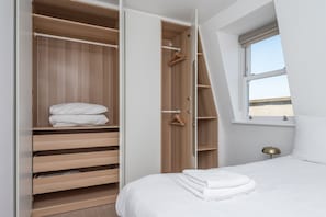 A bedroom with a large closet, a bed, and a window with a view. - 1850s Victorian Villa with Garden Views, Fulham (Greater London)