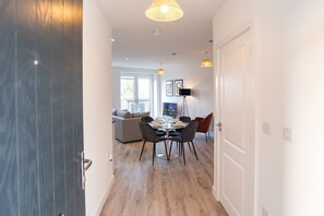 A modern interior with a dining area, a sofa, and a lamp. - Gym Access & Free Parking Near Birmingham (Balsall Heath)