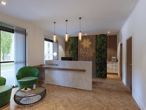 A reception desk with a sign reading 'Concierge' and 'Belgrave Village,' a green chair, a round table, and a herringbone wooden floor. - Gym Access & Free Parking Near Birmingham (Balsall Heath)