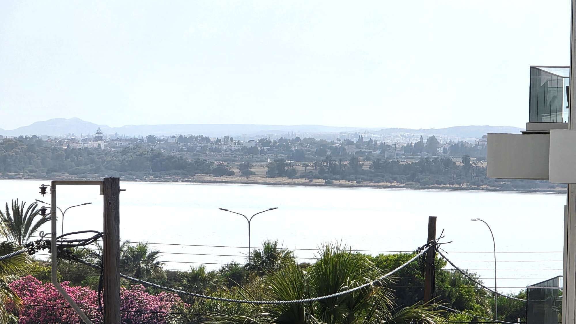 A view of a body of water with a distant cityscape and mountains.