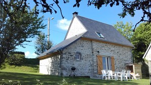 Une maison en pierre avec un toit en pente, une petite fenêtre et une porte.