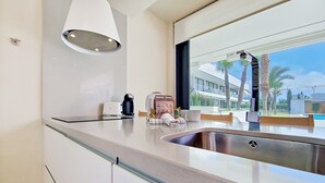 Een moderne keuken met een inbouwspoelbak, een koffiezetapparaat en een welkomstbord.