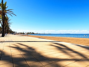 A paved walkway leading to a beach with palm trees and a clear blue sky. - Ground Floor Apartment with Direct Pool Access (Mar de Cristal)
