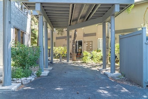 A covered walkway with columns, a gravel path, and a building with a number '5' on the left. - Stonehenge Condo #6 - Walk to River Run & Main Street (Ketchum)