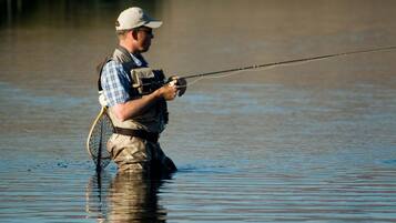 A person standing in water holding a fishing rod.