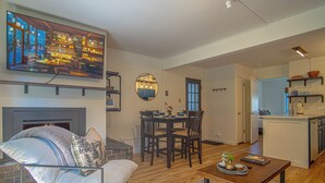 Una sala de estar moderna con chimenea, comedor y cocina.