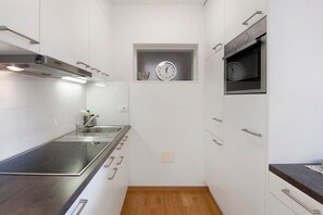 Una cucina moderna con forno integrato, una sveglia e una cappa aspirante in acciaio inox.