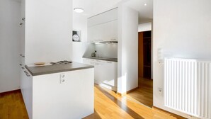 Una cocina moderna con armarios blancos, una encimera y un horno empotrado.