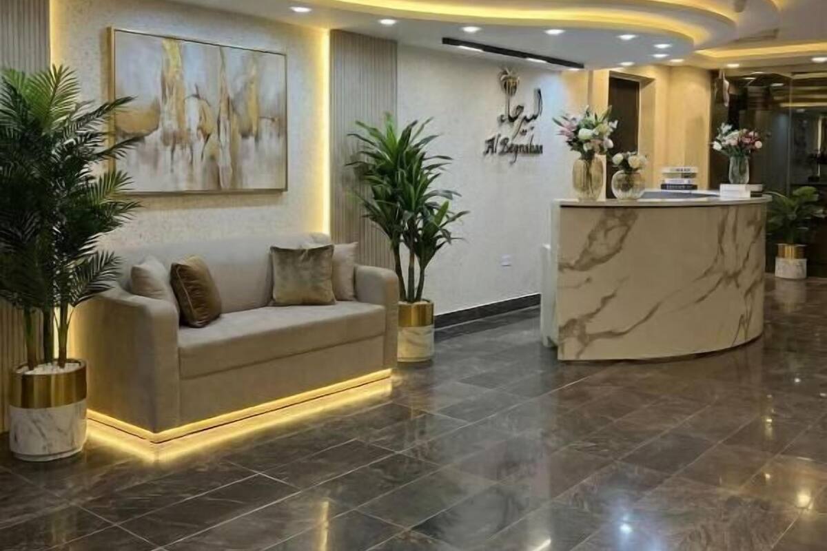 A lobby with a reception desk, a sofa, and potted plants.