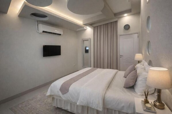 A modern hotel room with a bed, a flat-screen TV, an air conditioning unit, a bedside lamp, and a door.