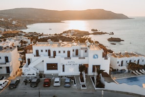 A white building with a sign reading 'HOTEL ALBATROS' and a pool area.