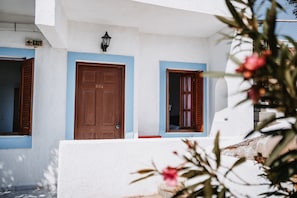 Un edificio con fachada blanca, detalles azules y puertas de madera.