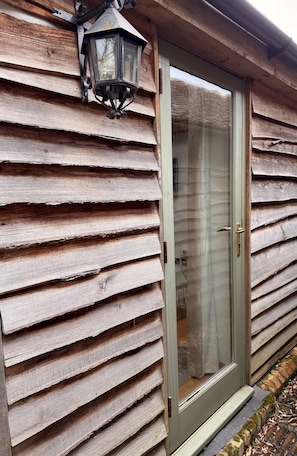 A wooden exterior with horizontal siding and a glass door with a sliding mechanism.