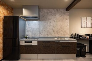 A modern kitchen with a built-in stove, a sink, and a large refrigerator. - JAPAVISTA Hinata (KONOHANA WARD)