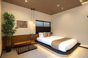 Une chambre à coucher moderne avec un lit, une table de chevet, un banc et une plante en pot.
