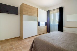 Ein Schlafzimmer mit einem Bett, einem Kleiderschrank und einem fenster mit Vorhängen.