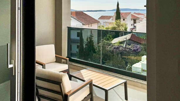 Ein Balkon mit Blick auf ein Gewässer und Gebäude.