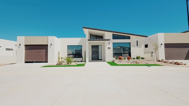 A modern two-story house with a garage, a driveway, and a well-maintained lawn. - Casa Luna  By FMI Rentals (Puerto Peñasco)