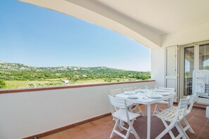 A balcony with a table set for dining, overlooking a green landscape with hills. - Spacious and comfortable 142 square meters apartment, perfect for six people, located on the first floor of a two-family building.The property is located in a quiet area surrounded by nature, ensuring a relaxing stay. A car is recommended.The accommodati (Arzachena)