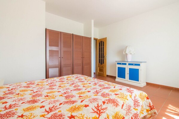 Une chambre à coucher avec un lit, une armoire, un meuble et une porte.
