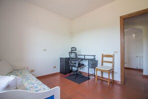 Une chambre à coucher avec un lit, un bureau, une chaise et une armoire.