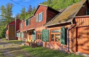 A rustic wooden building with a brick foundation, large windows, and green shutters. - 10 bedroom amazing home in Sitzendorf (Sitzendorf)