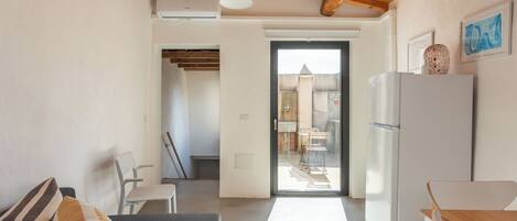 A modern kitchen with a refrigerator, a dining table, and a bench.