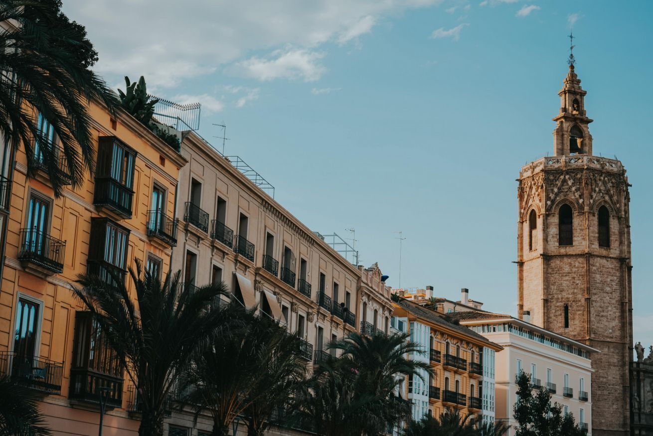 Un edificio histórico con una torre de campanas, varios balcones y un cielo despejado.