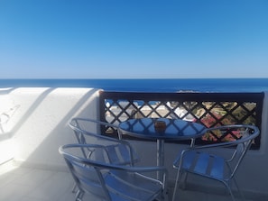 Ein Balkon mit Tisch und Stühlen mit Blick auf die Küste.