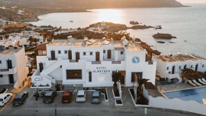 Un bâtiment blanc avec une enseigne indiquant « HÔTEL ALBATROS » et un espace piscine.