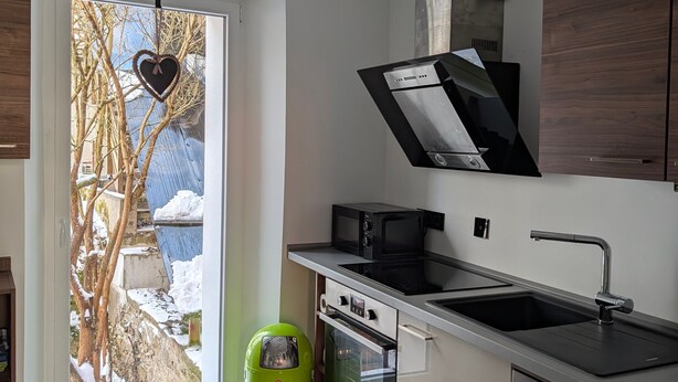A modern kitchen with a built-in oven, microwave, and stainless steel sink. - Apartment “Epprechtstein” with Wi-Fi (Kirchenlamitz)