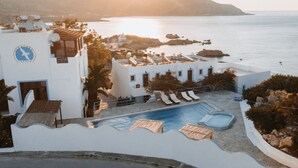 Un hôtel doté d’une piscine, de chaises longues et offrant une vue sur la mer.