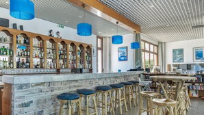 Un espace bar avec des tabourets en bois, un comptoir en marbre et une variété de bouteilles.