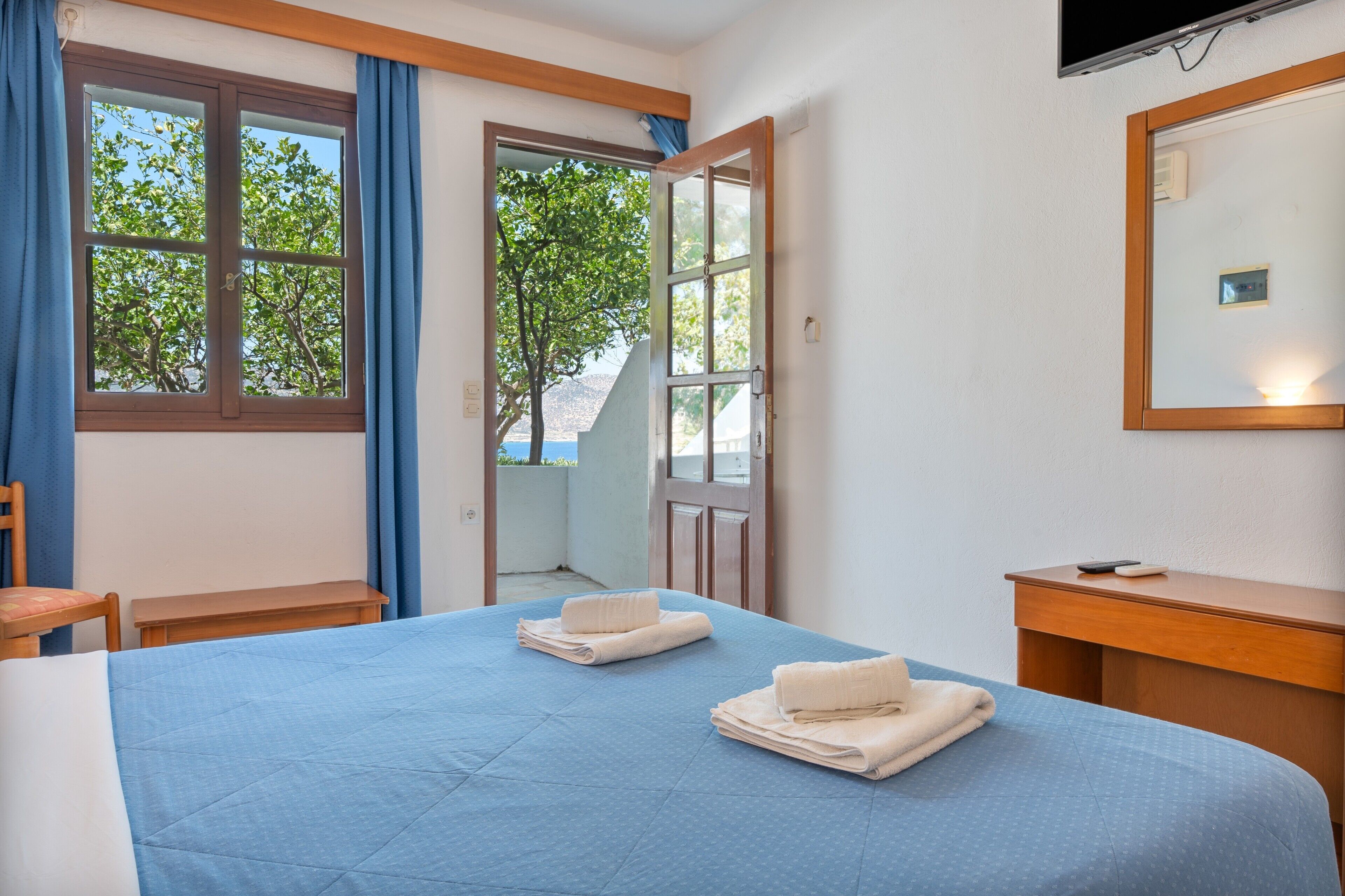 Une chambre d’hôtel avec un lit, une chaise, un bureau et un téléviseur.