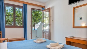 Une chambre d’hôtel avec un lit, une chaise, un bureau et un téléviseur.