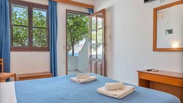 Une chambre d’hôtel avec un lit, une chaise, un bureau et un téléviseur.