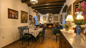 A dining area with a wooden table and chairs, a fireplace, and framed artwork on the walls. - Beautiful home in Puente Genil (Puente Genil)