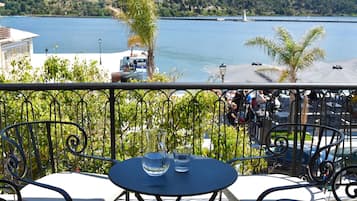 Varanda com mesa e cadeiras com vista para um corpo de água.