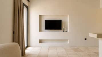 Uma sala de estar moderna com uma televisão de tela plana na parede, um sofá e uma janela grande com cortinas.