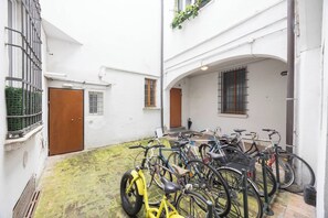 Ein Innenhof mit abgestellten Fahrrädern, einer Tür und einem Fenster.