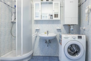 A bathroom with a shower, sink, and washing machine. - San Marco, Florence By Short Holidays (Florence)