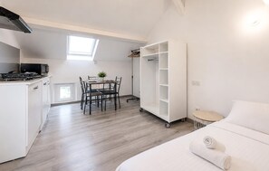 A compact room with a kitchenette, dining area, and a bed with a rolled towel. - 1 bedroom amazing apartment in savignac-les-églises (Savignac-les-Églises)
