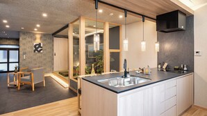 Een moderne keuken met een centraal eiland, houten vloeren en hanglampen.